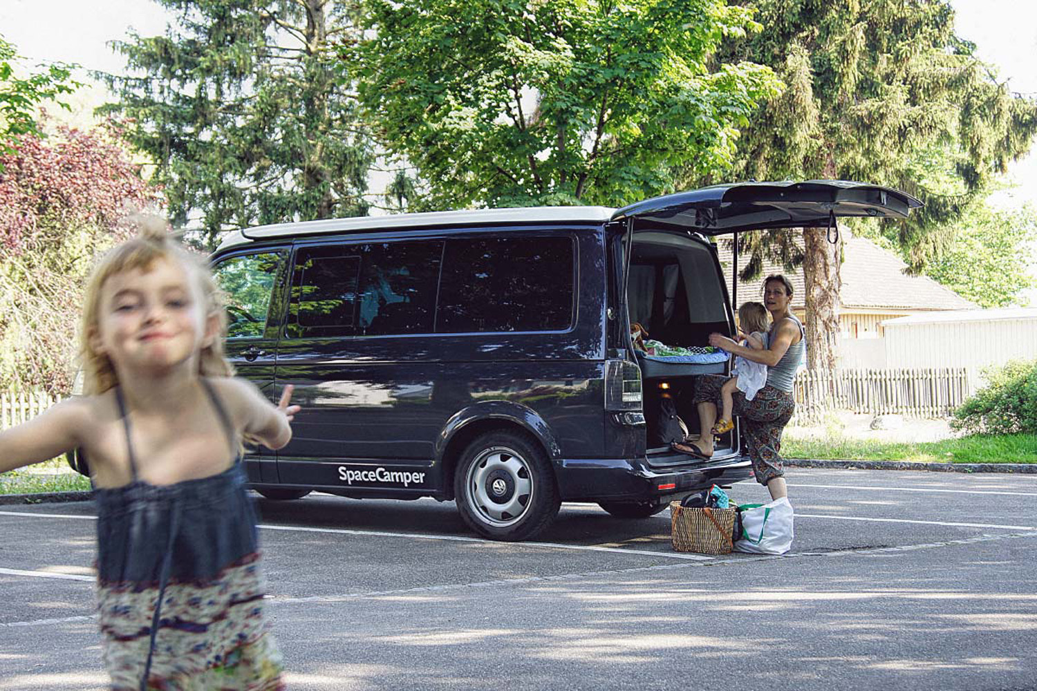 LIFE-for-FIVE-Elternzeit-Mama Tina und die beiden Mädels mit dem SpaceCamper auf einem Parkplatz am Bodensee