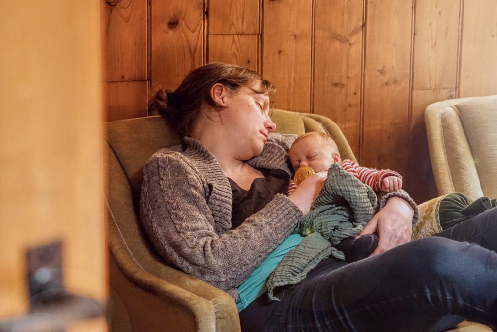 LIFE-for-FIVE-Elternzeit-Mama mit Baby schlafend auf einem Sessel