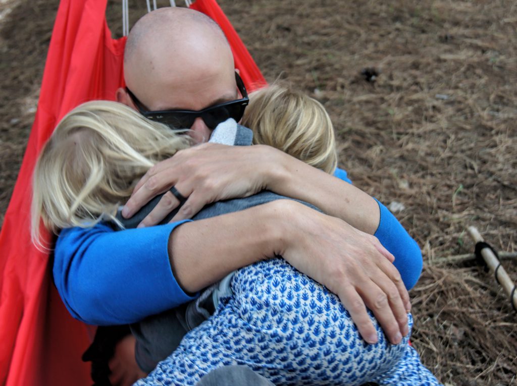 LIFE-for-FIVE-Elternzeit- Papa mit zwei Töchtern kuschelnd in Hängematte