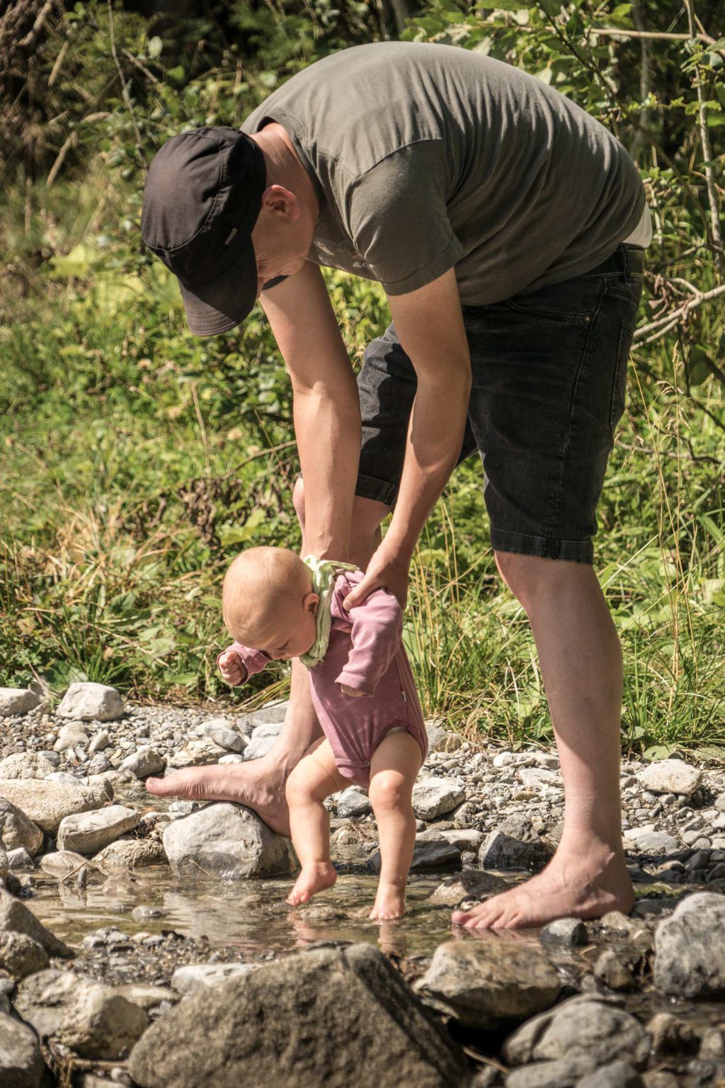 LIFE-for-FIVE-fernweh-Papa hält Füsse von Baby in Gebirgsbach