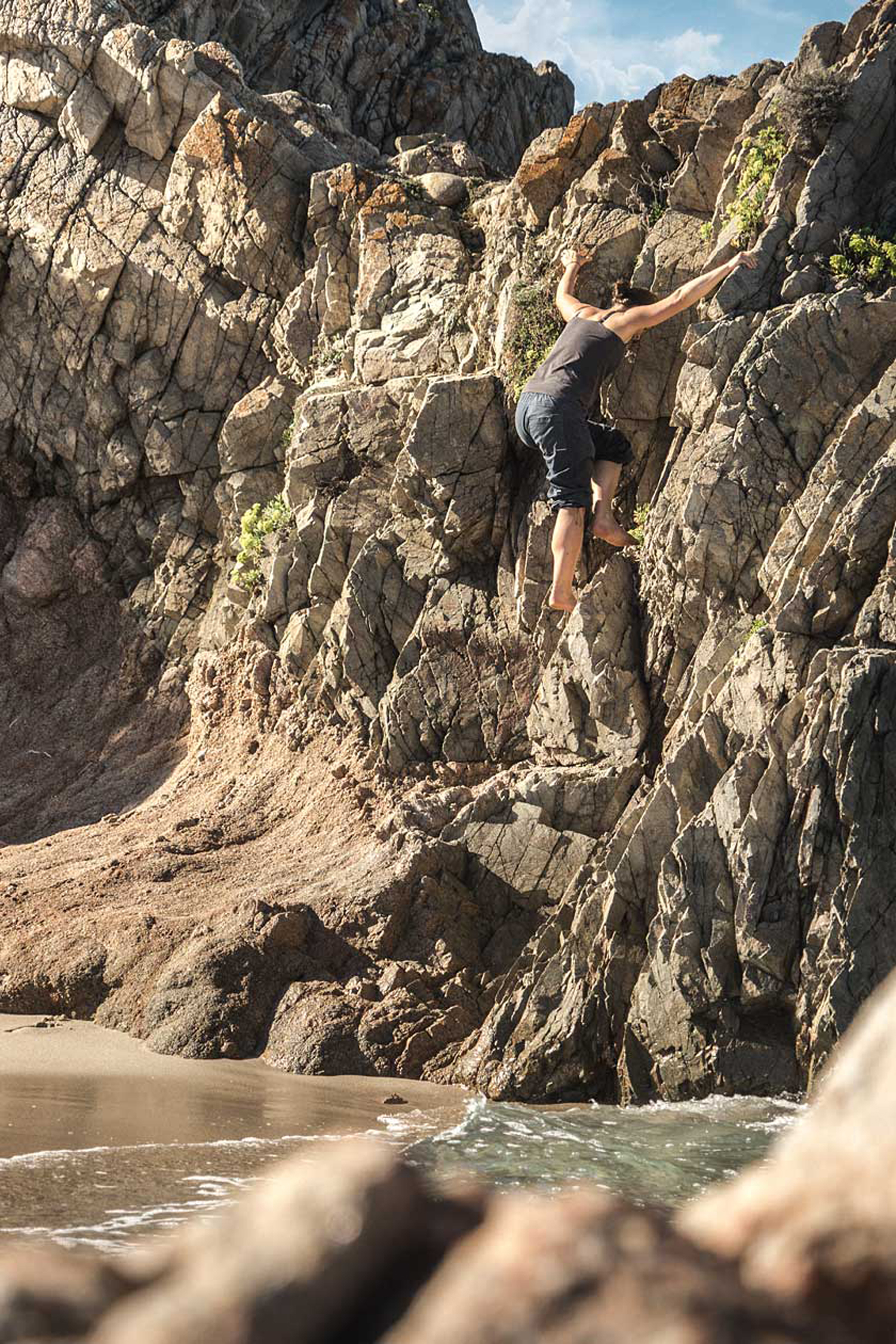 LIFE-for-FIVE-Pack-System-Mama Tina klettert an einer kleinen Felswand am Strand.