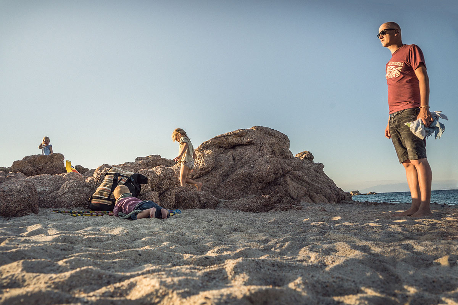 LIFE-for-FIVE-Sardinien-mit-Kindern-Papa Daniel mit seinen Mädles am Strand mit Felsen.