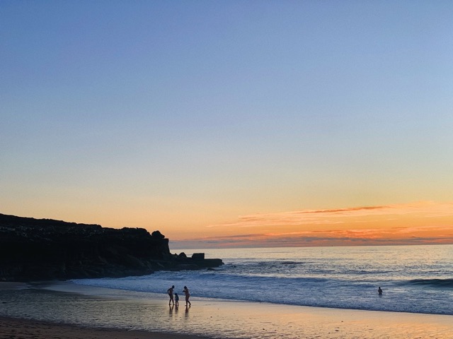 Familie am Strand von Portugal beim Sonnenuntergang - ein ruhiger Moment auf einer Portugal-Reise.